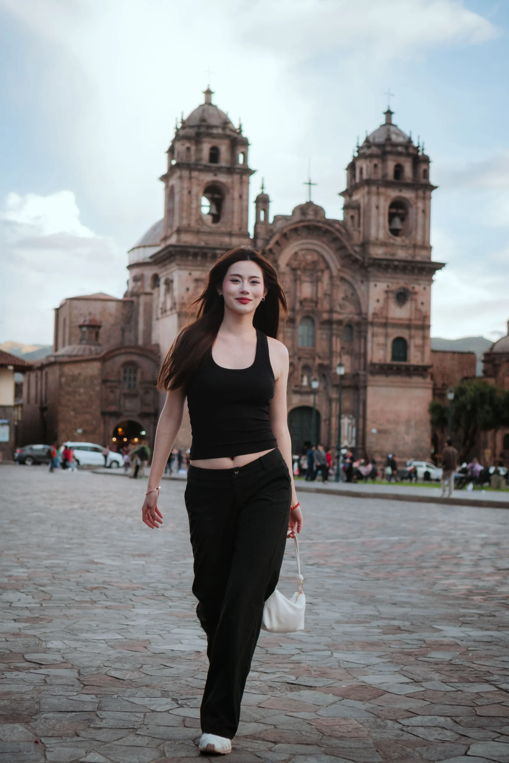 Woman walking through Plaza de Armas on a sunny day in Cusco