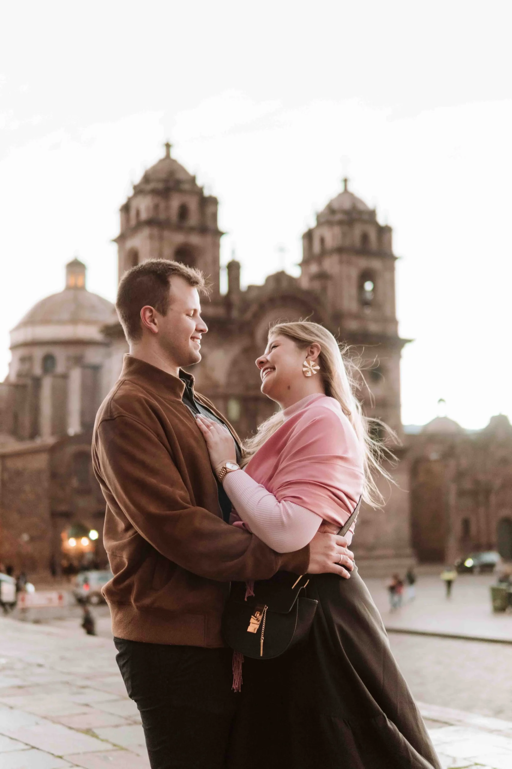 Couple embracing in front of Cusco Cathedral during a romantic photoshoot.