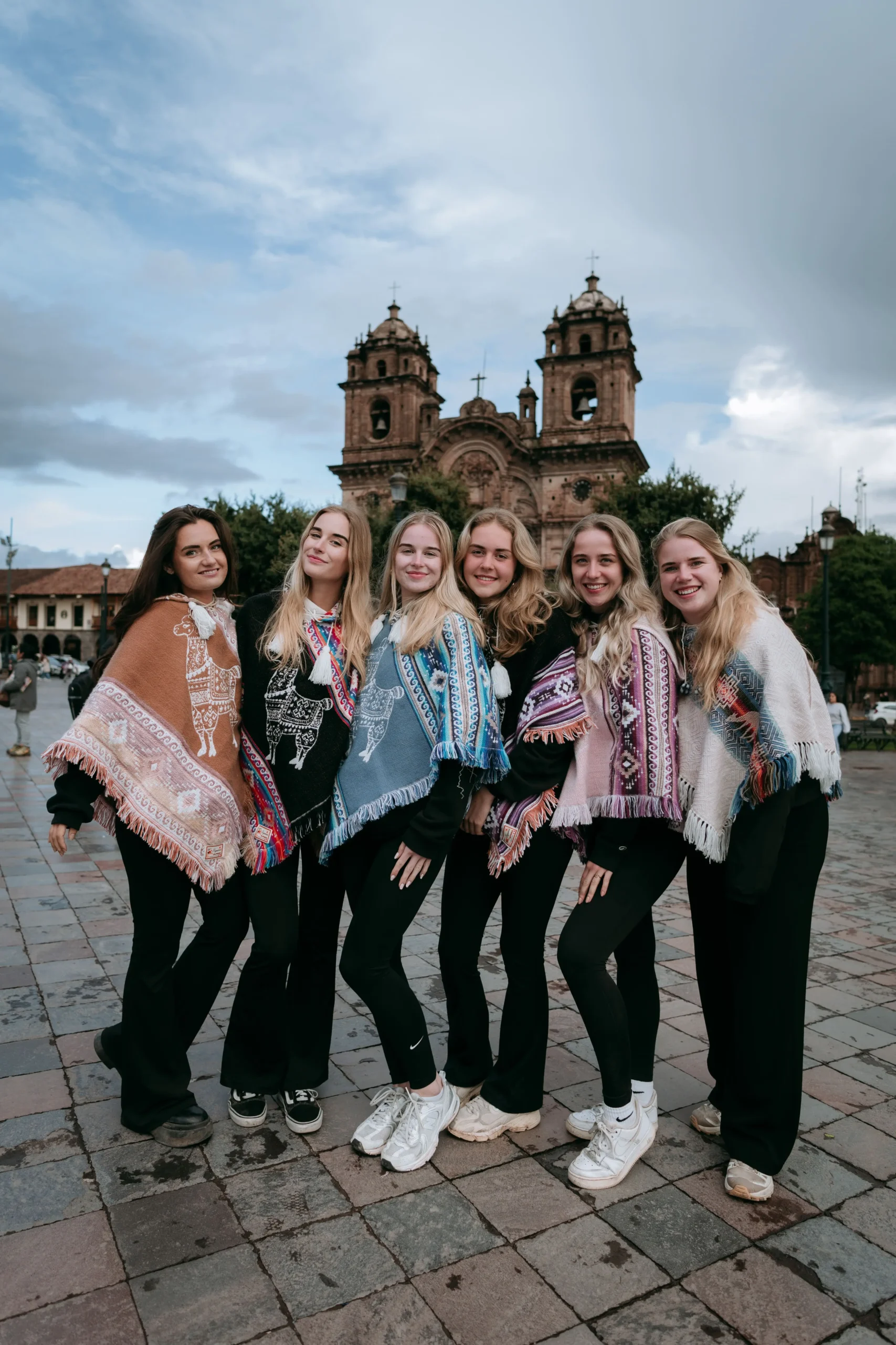 Group of friends smiling at Cusco’s Plaza de Armas, enjoying the Cusco city tour