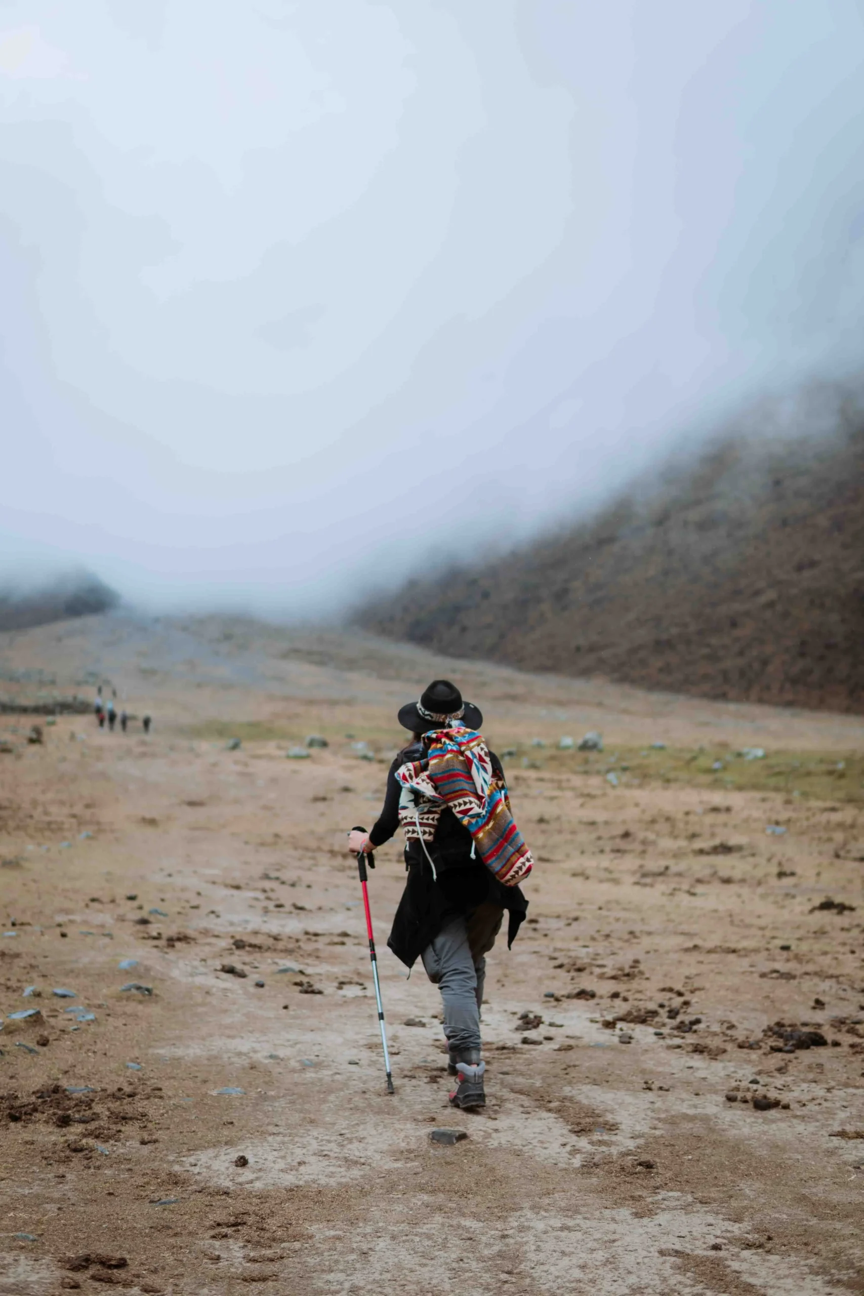 Solo traveler hiking in the misty mountains of Humantay