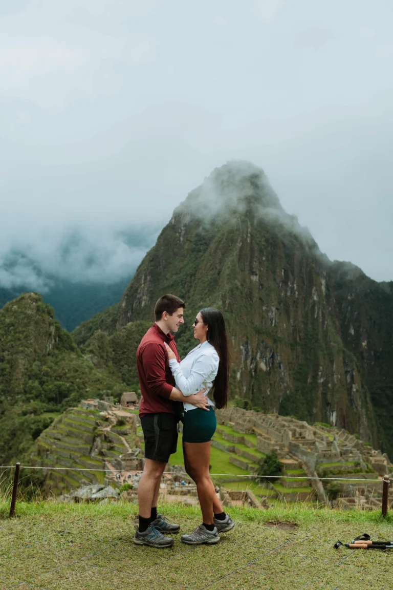 Couple kissing at a scenic viewpoint of Machu Picchu