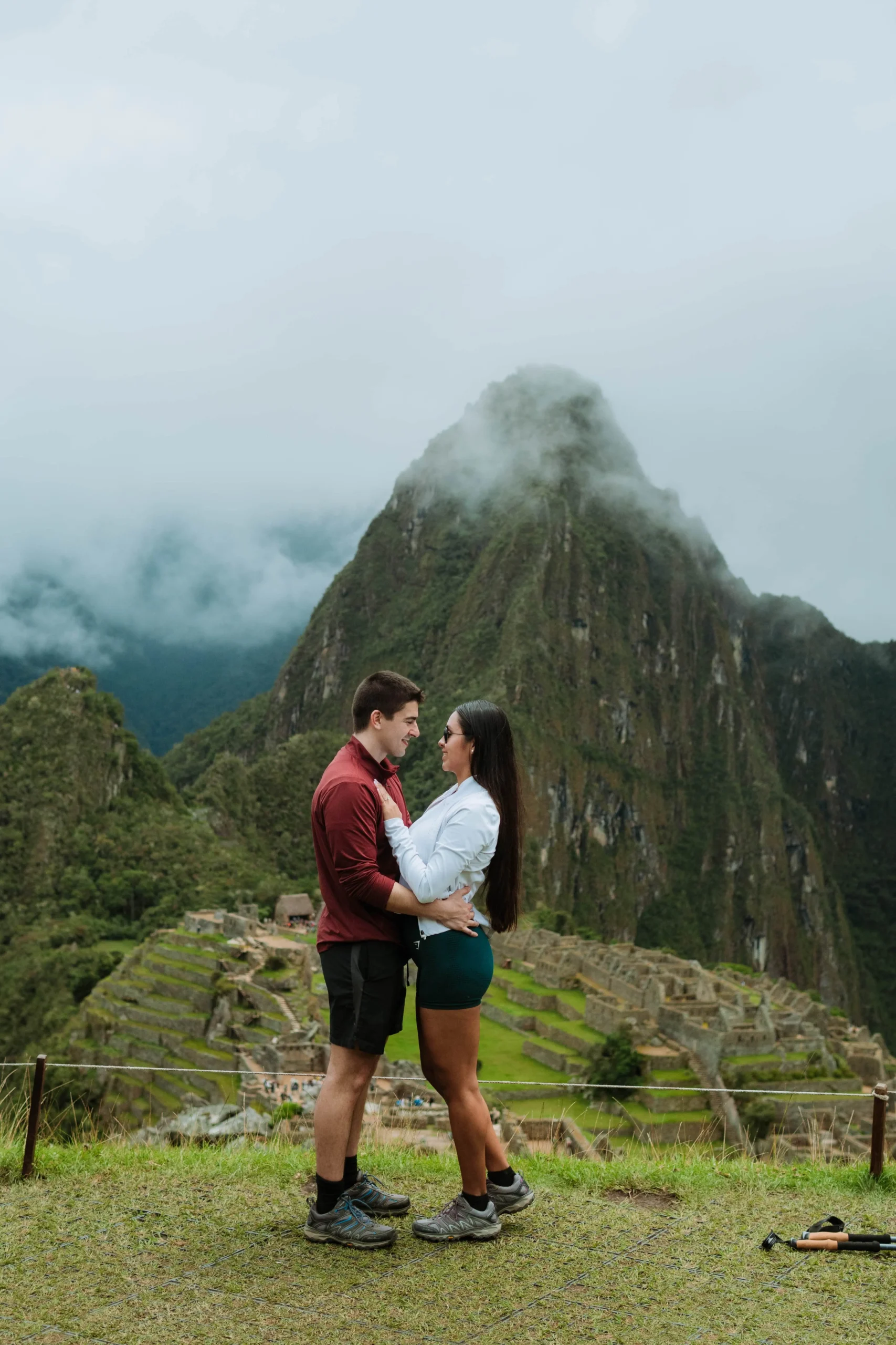 Couple kissing at a scenic viewpoint of Machu Picchu