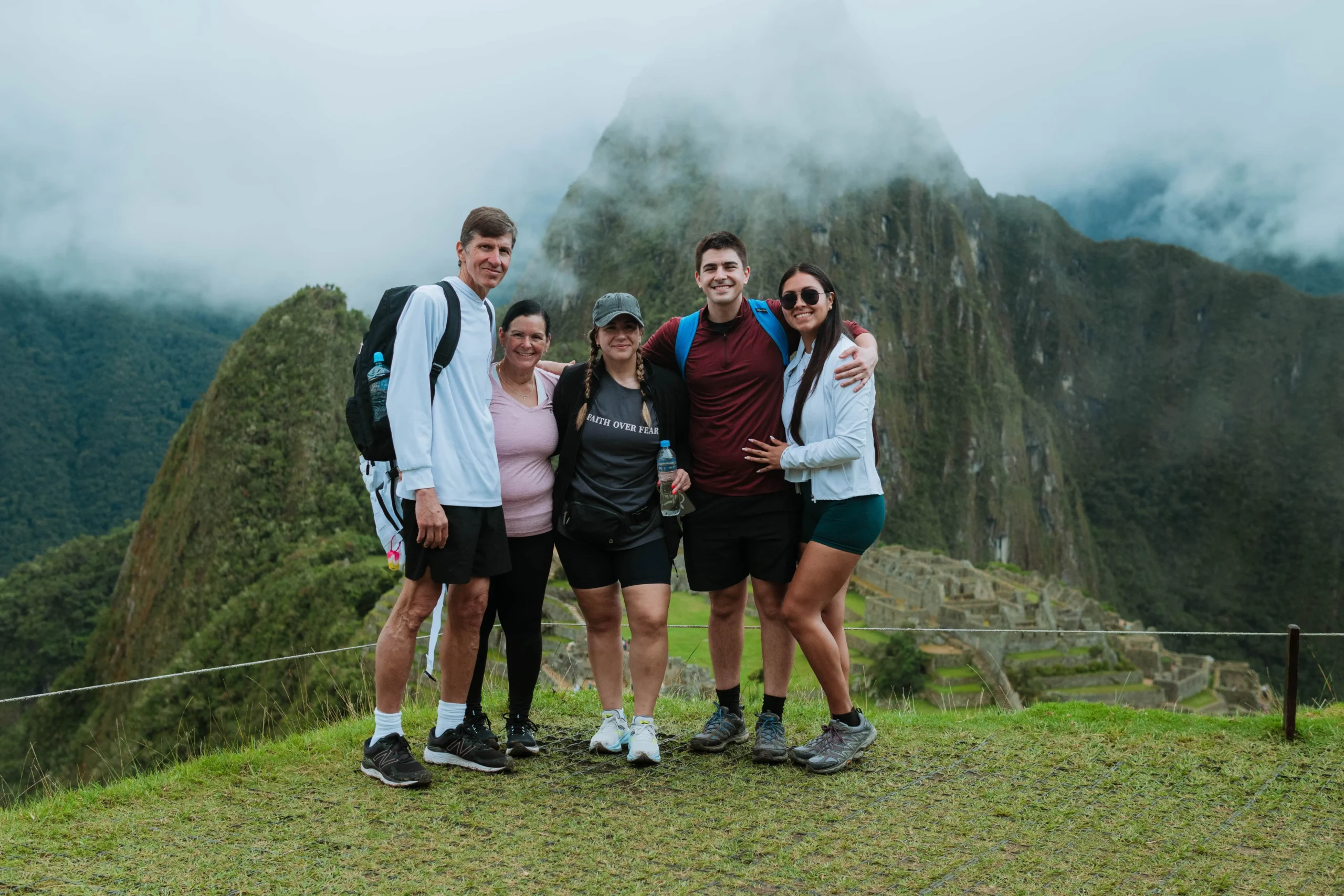 Hiking group posing with mountains in the background at Machu Picchu