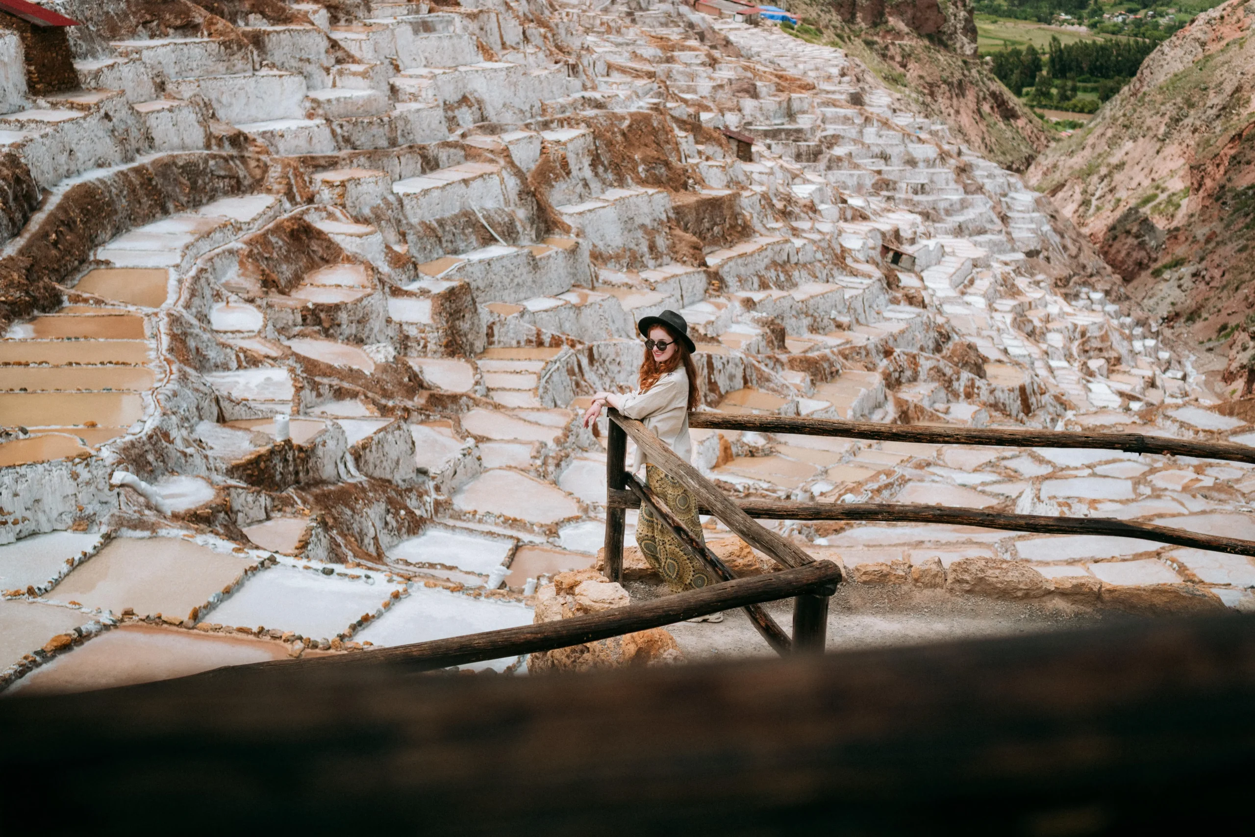 View of the salt terraces and traveler at Maras Salt Mines