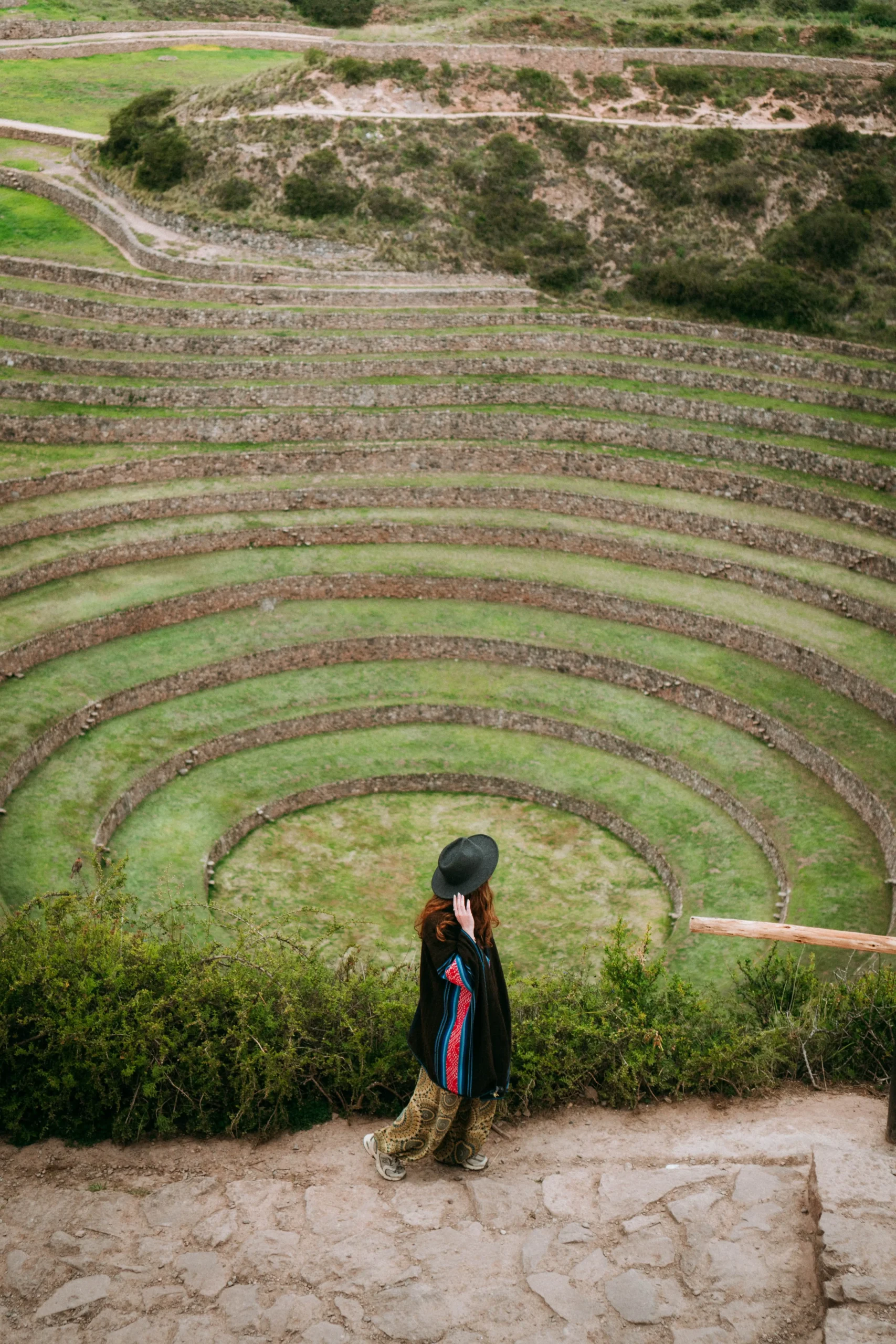Traveler walking along the Inca terraces of Moray