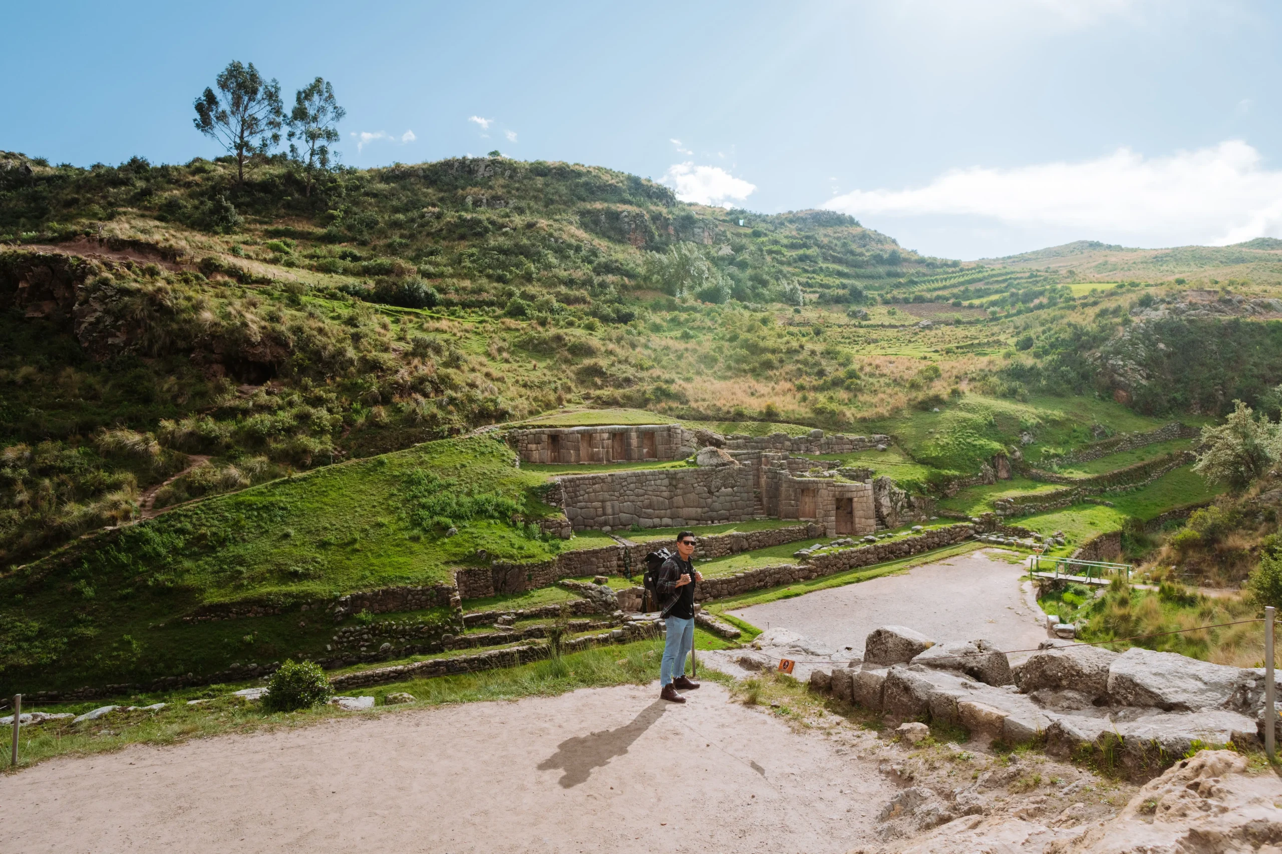 Tourist exploring the Tambomachay archaeological site near Cusco